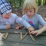 Children spelling letters with sticks