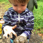 Child exploring patterns in the mud