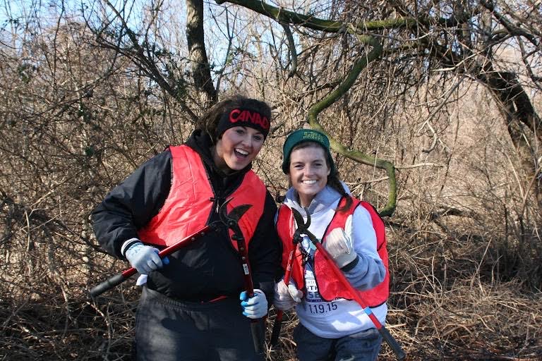 Two volunteers smiling and holding hedge clippers in our forest