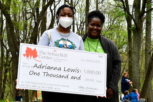 2022 Youth Meigs Award Winner Adrianna Lewis posing with Education Director Aaliyah Ross, holding a large check for one thousand dollars