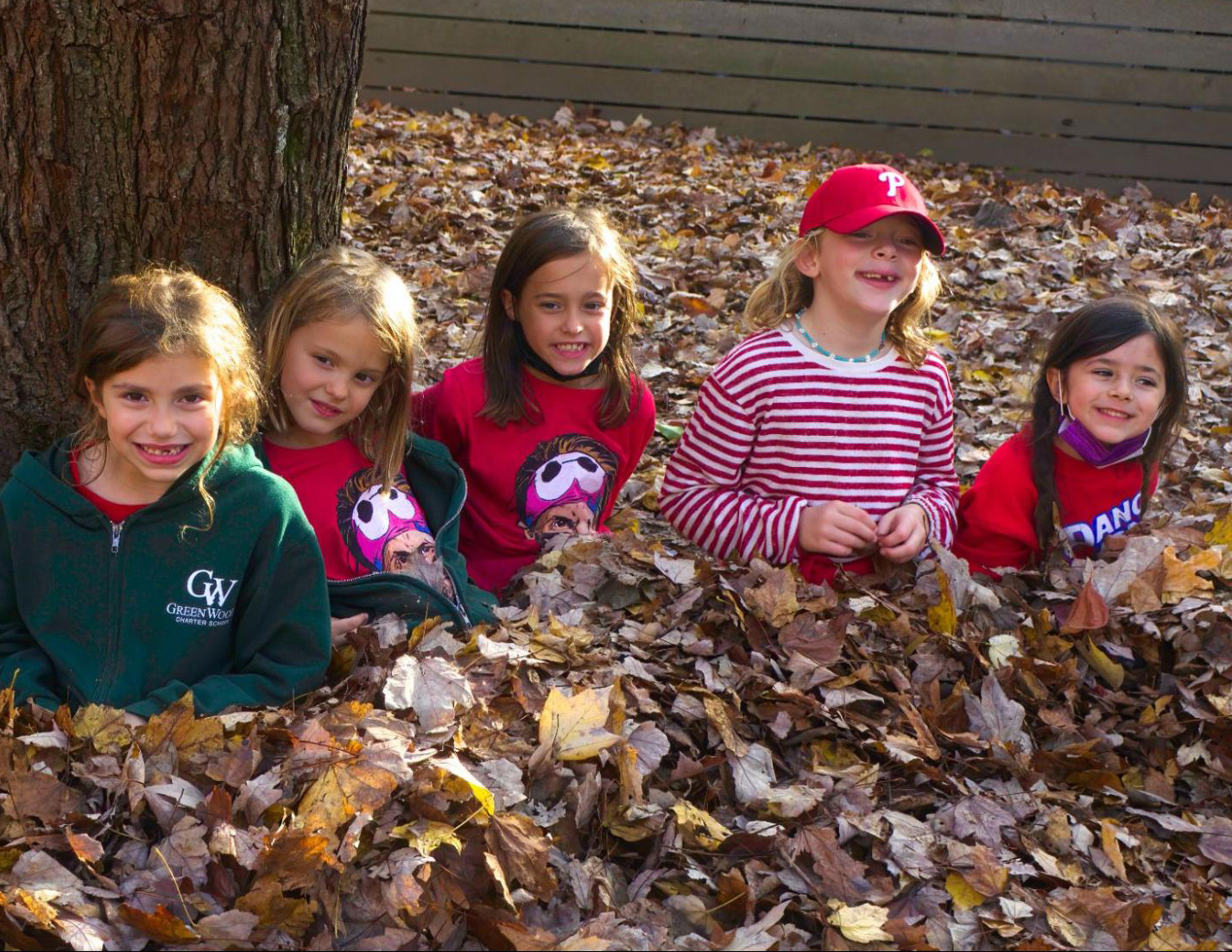 Children sitting in a pile of leaves